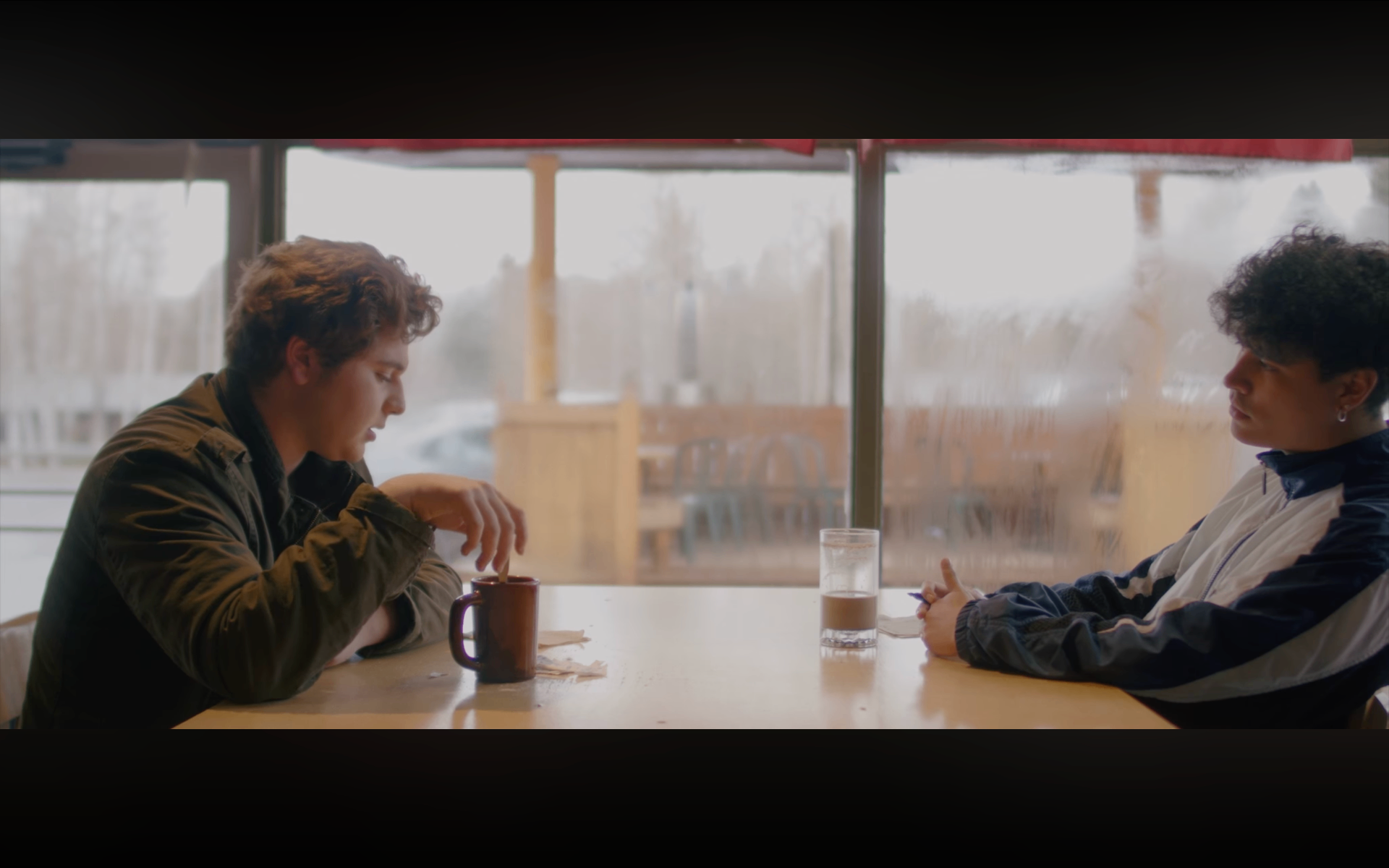 A real moment in a coffee shop — two people sitting, talking, present